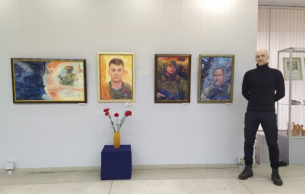 Владимир Киреев на фоне своих работ (Серия «Согласно присяге»: «Псалом 90», «Гвардии матрос Никита Будник», «Позывной «Сеть», «Позывной «Скиф»)