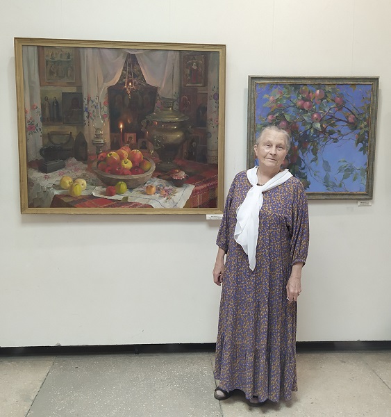 Лариса Минченко на фоне своих работ